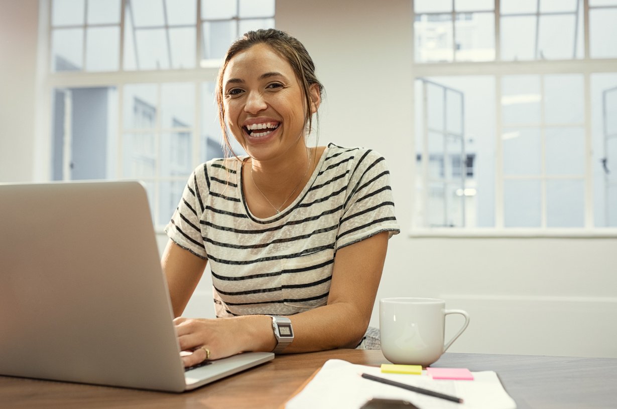 Cheerful Latin Woman Using Laptop