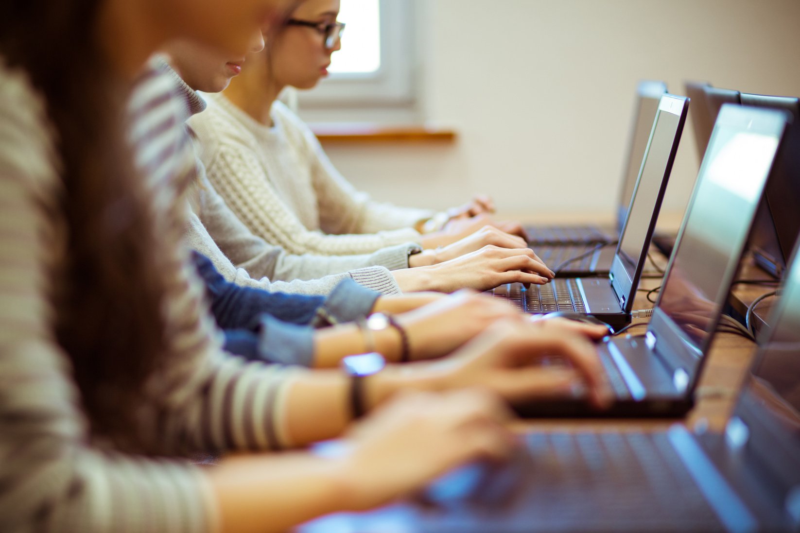 Female students learning computer programming on laptops